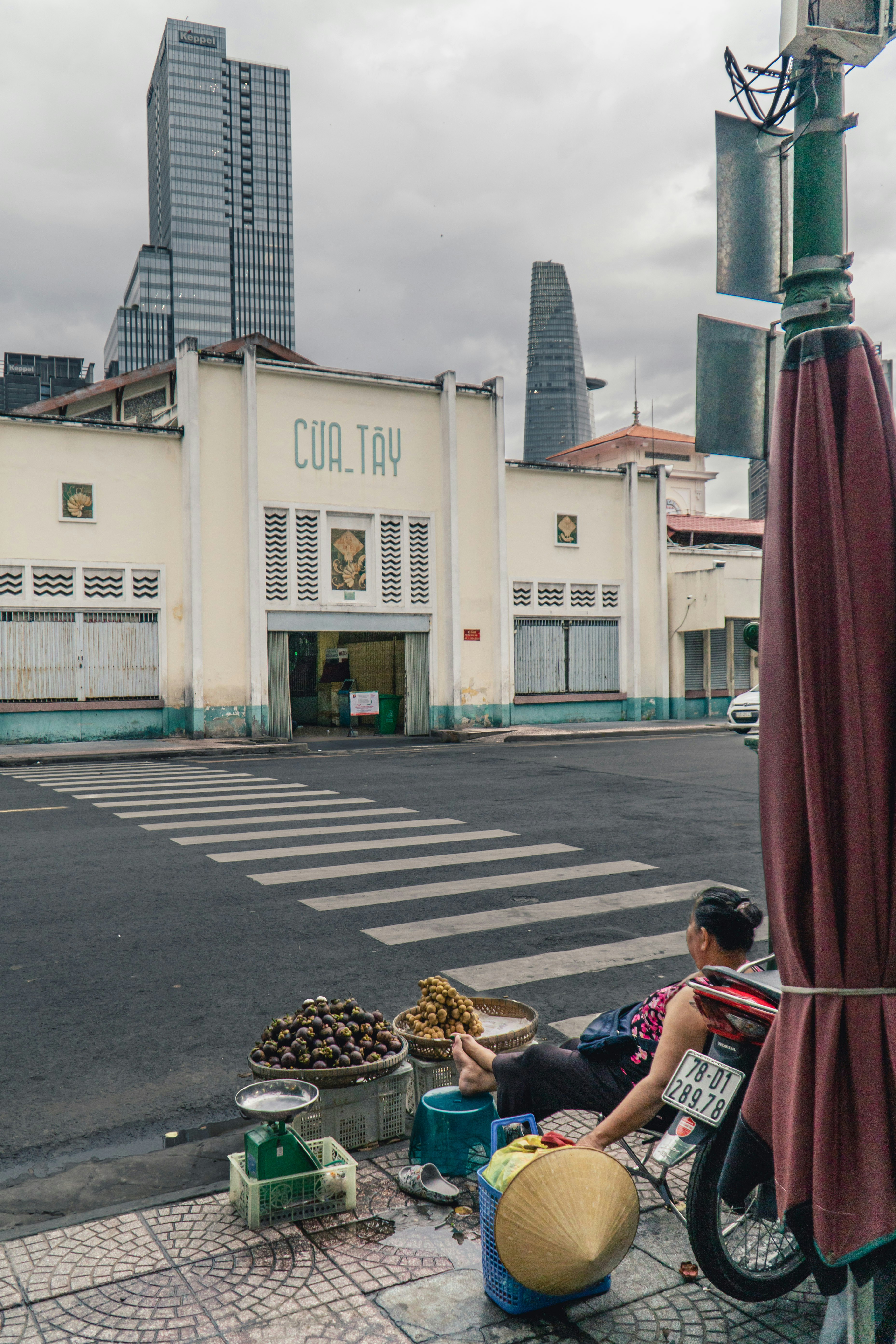 man in red robe sitting on sidewalk during daytime